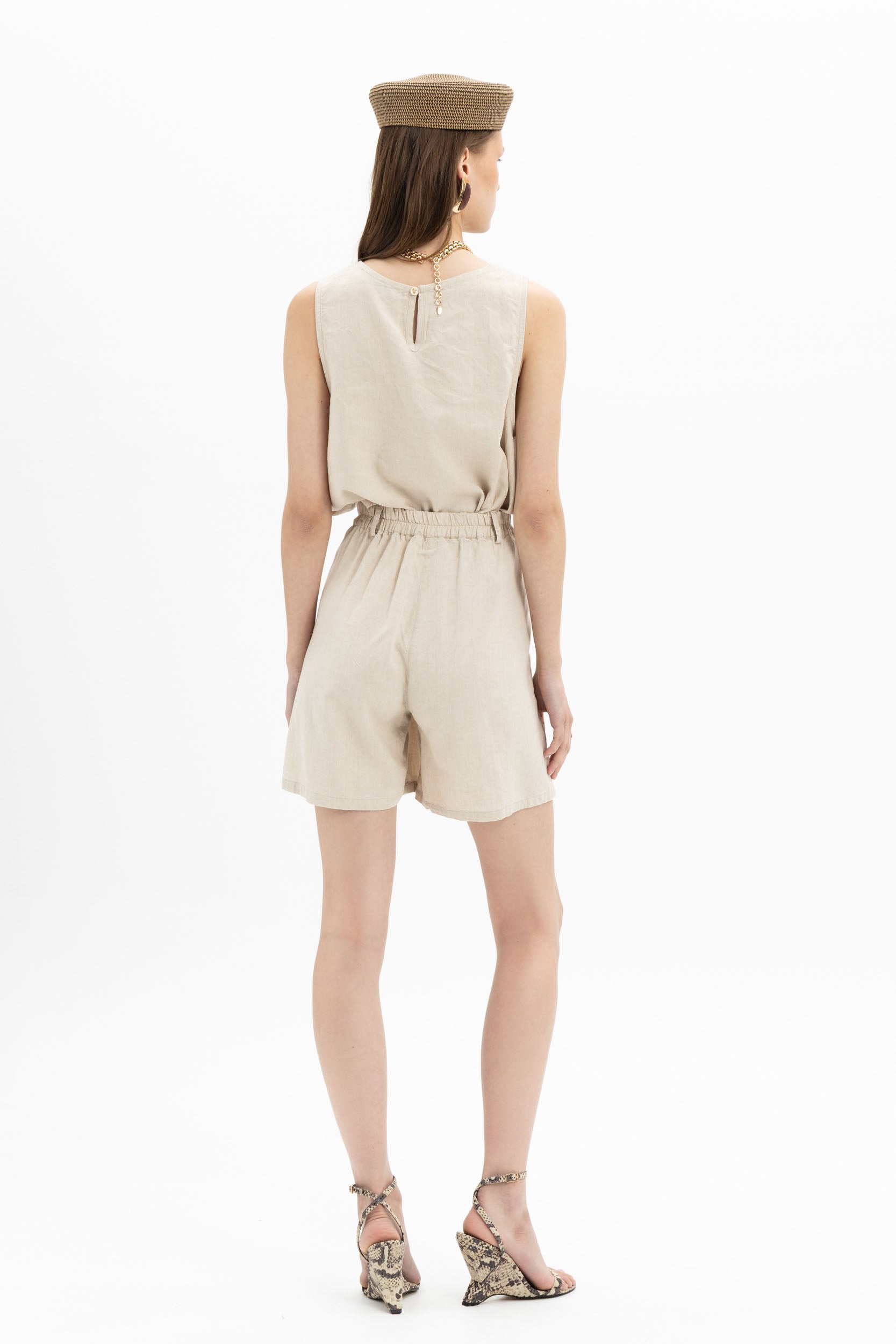 Beige linen Bermuda shorts from MYT worn with a sleeveless tank top, showcasing casual summer style and comfortable fit.